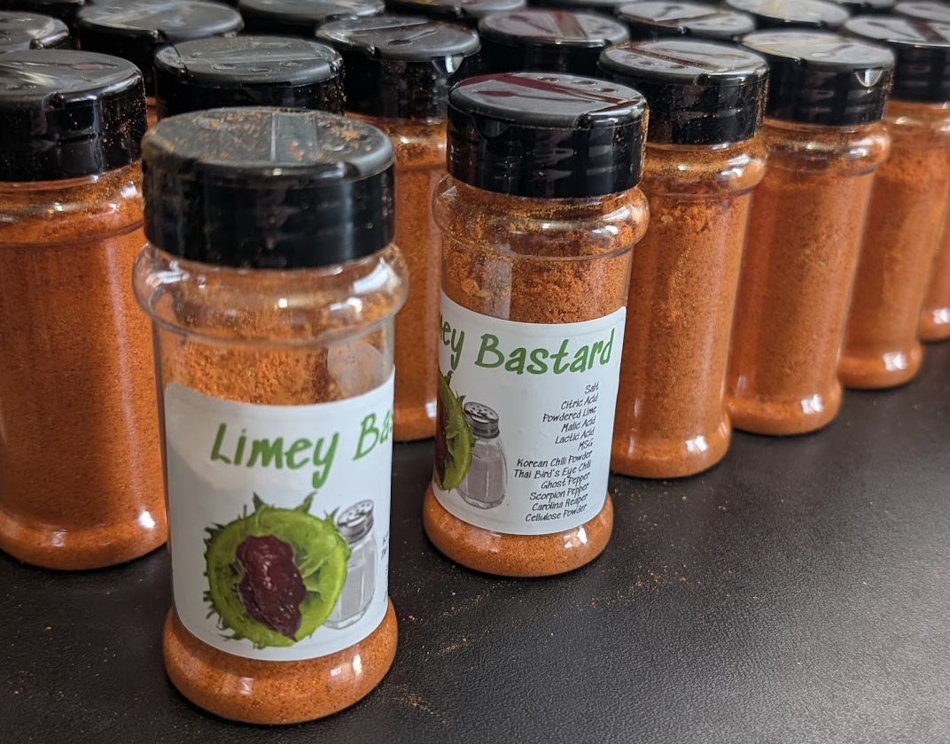 Limey Bastard spice jars with green labels, filled with reddish-orange blend